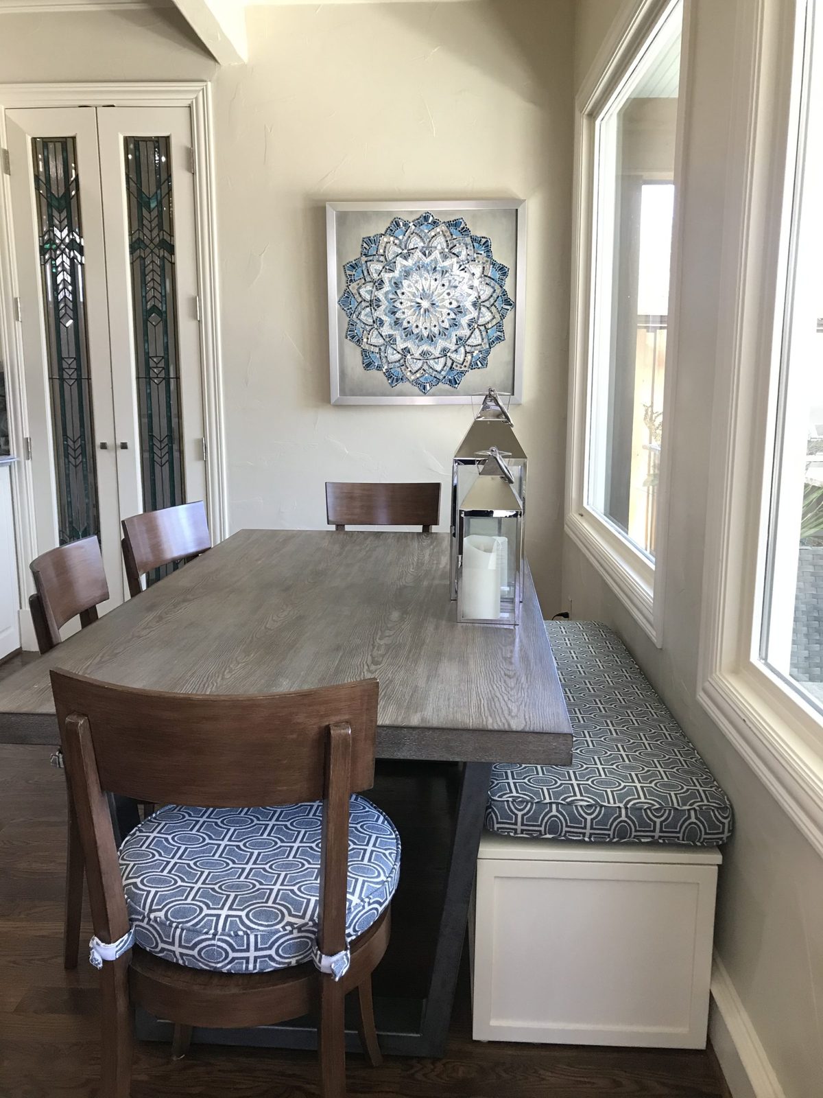 Breakfast nook with banquette seating beside a shaded window