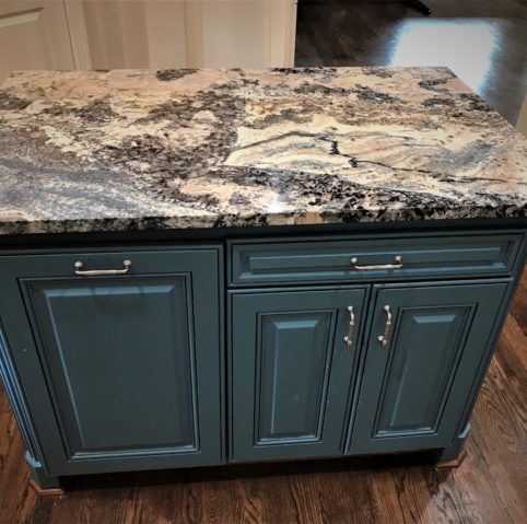 Kitchen island detail with granite counter and painted cabinetry