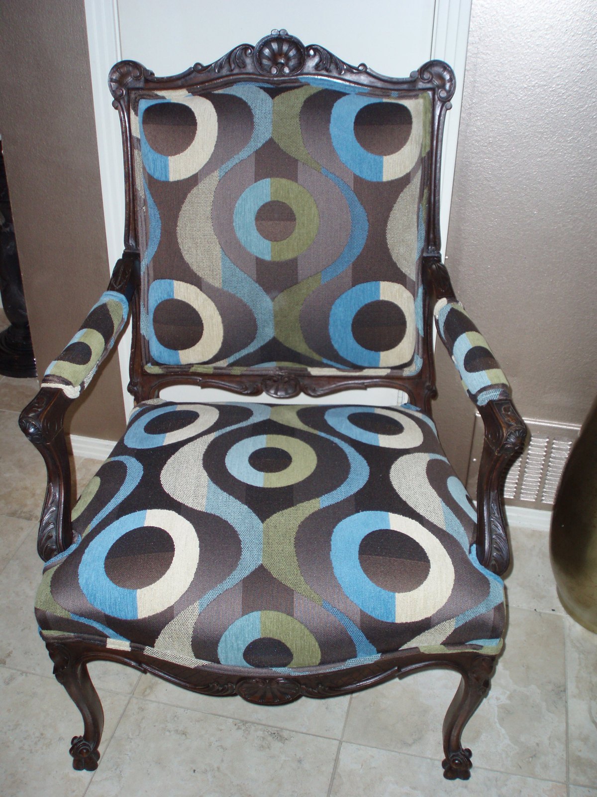 The same carved armchair reupholstered in a bold blue, brown and cream circle print