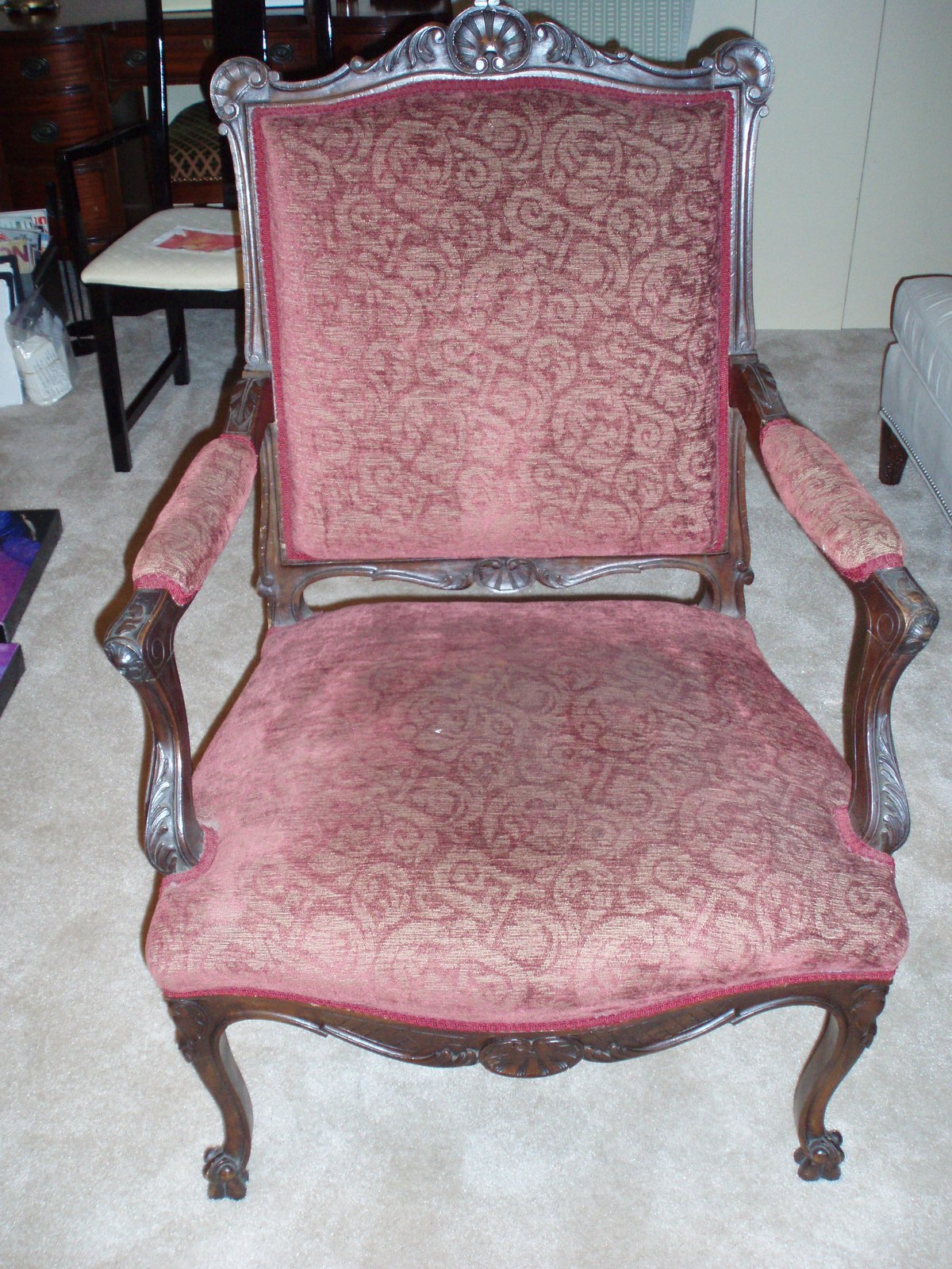 Carved antique armchair in worn pink damask