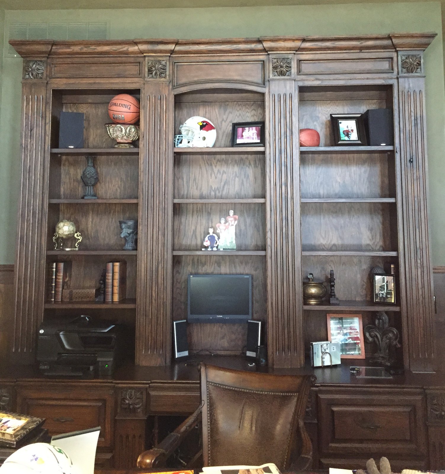 Three-bay dark wood built-in with a desk and open shelving