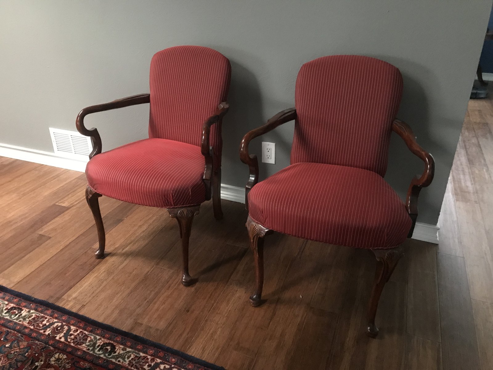 Two armchairs in plain red upholstery with natural wood frames