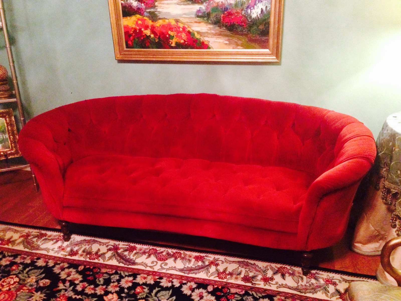 Bright red tufted sofa on a dark patterned rug