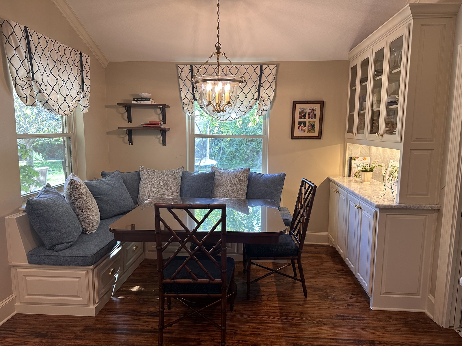 Built-in breakfast banquette with navy cushions and roman shades