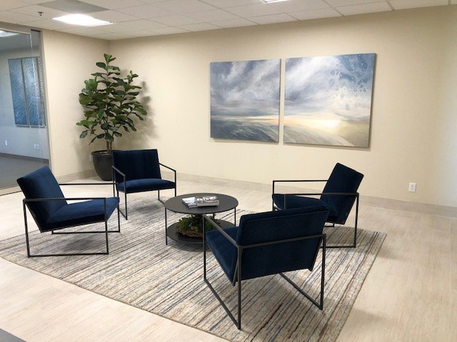 Executive lounge with navy leather chairs and a two-panel seascape