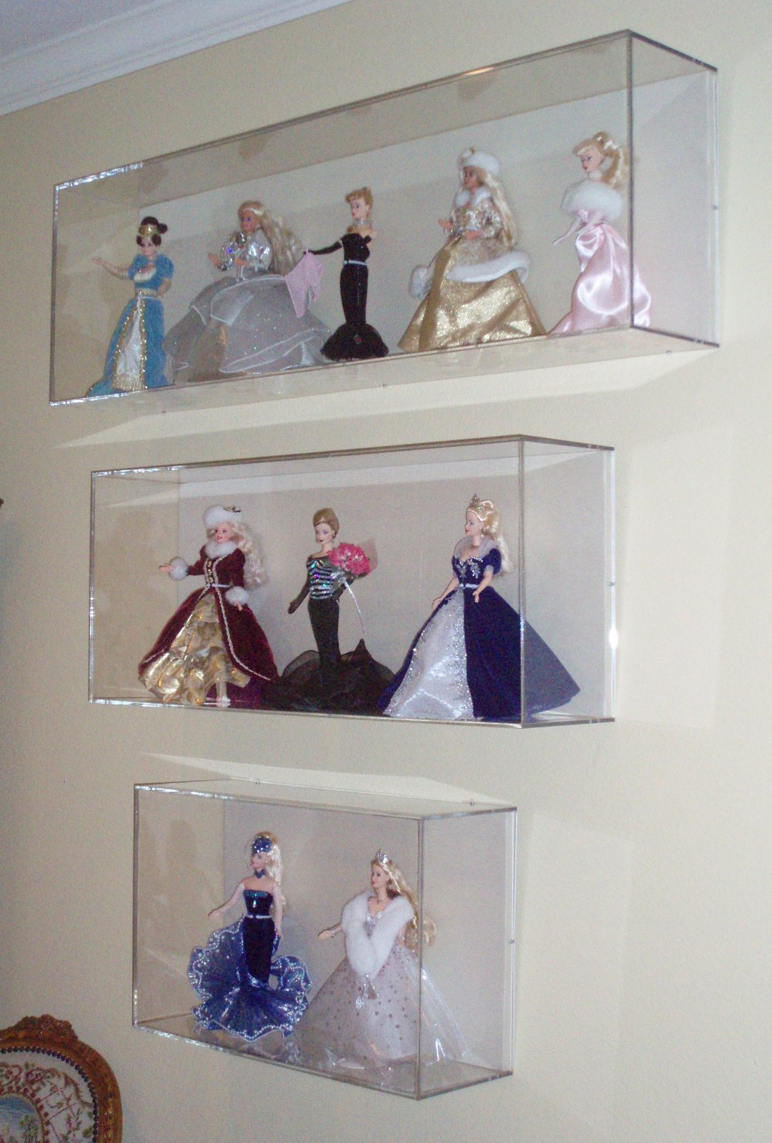Wall-mounted acrylic cases displaying a costume doll collection