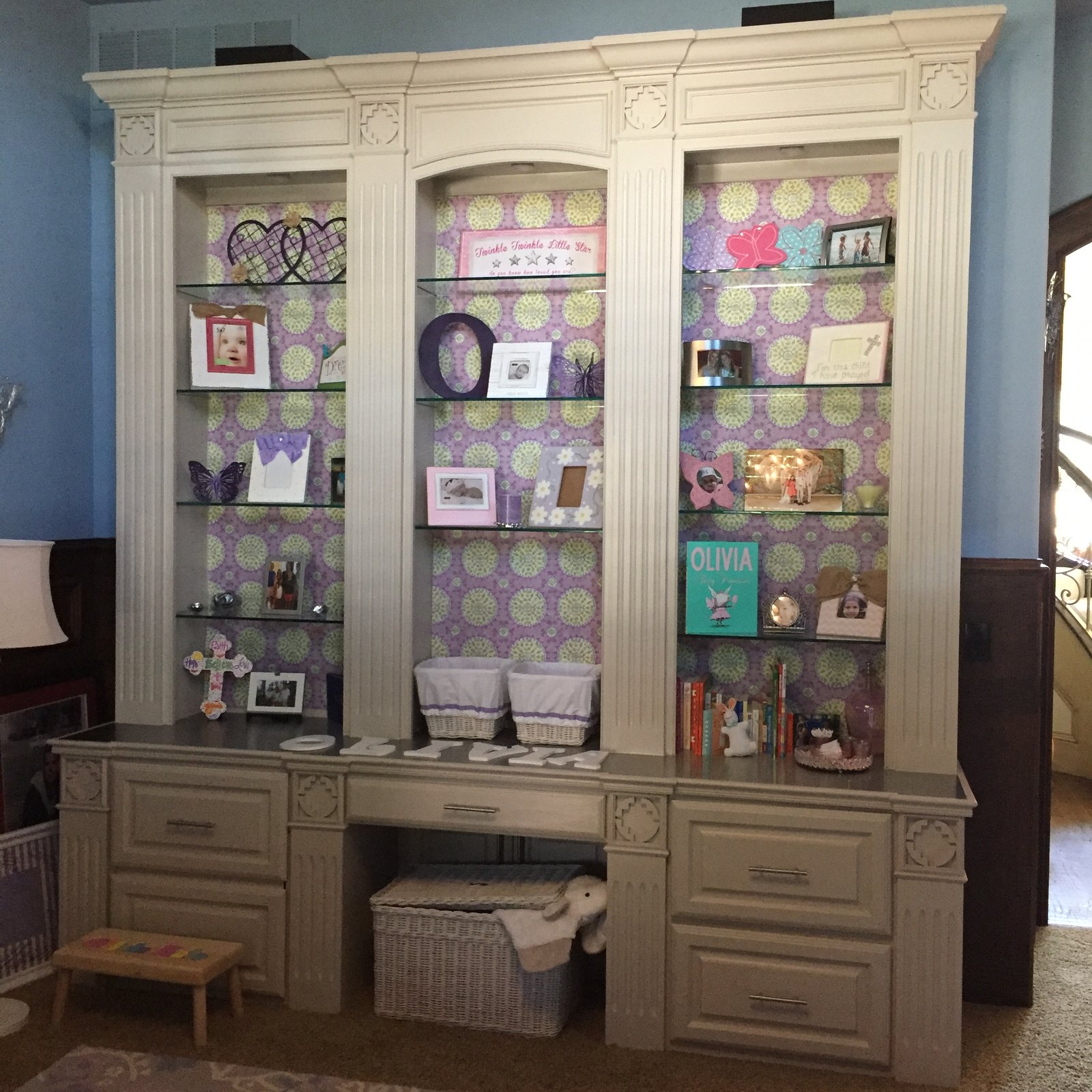Built-in bookshelves with fabric-backed panels and a stainless steel top
