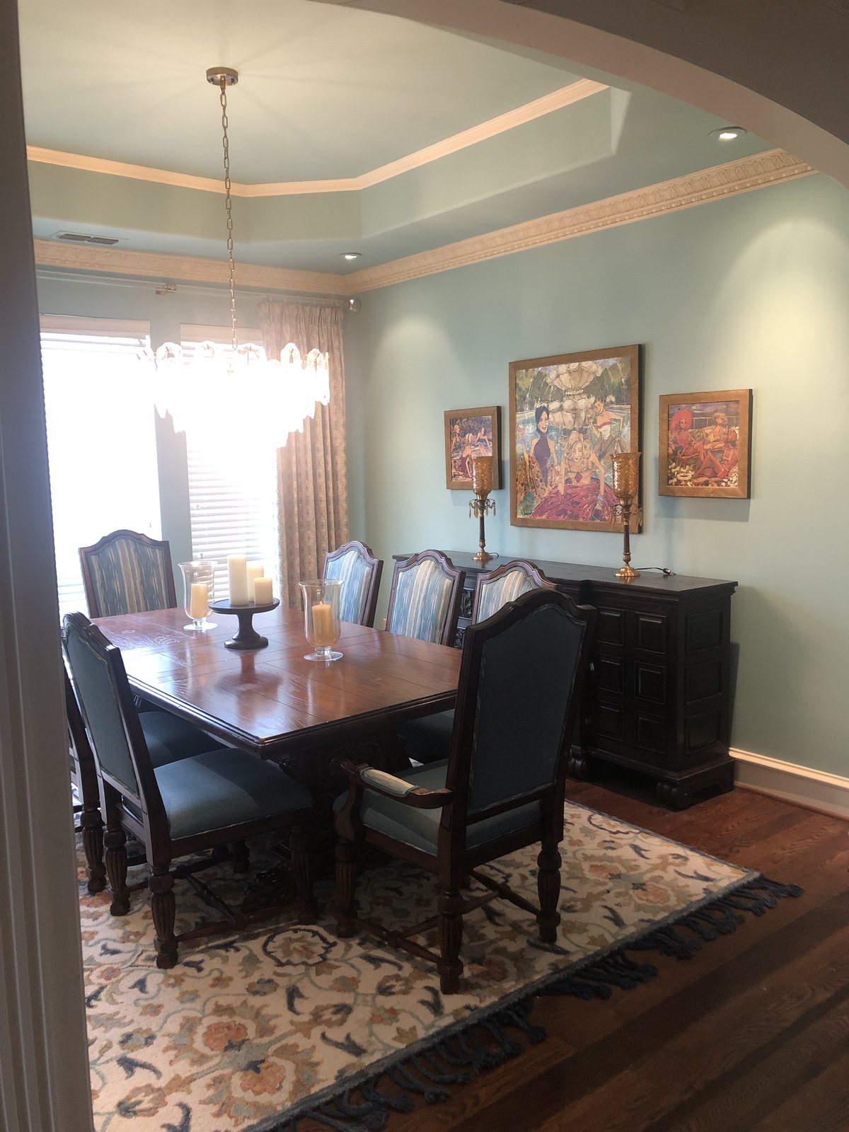 Formal dining room with a dark table, buffet and framed art