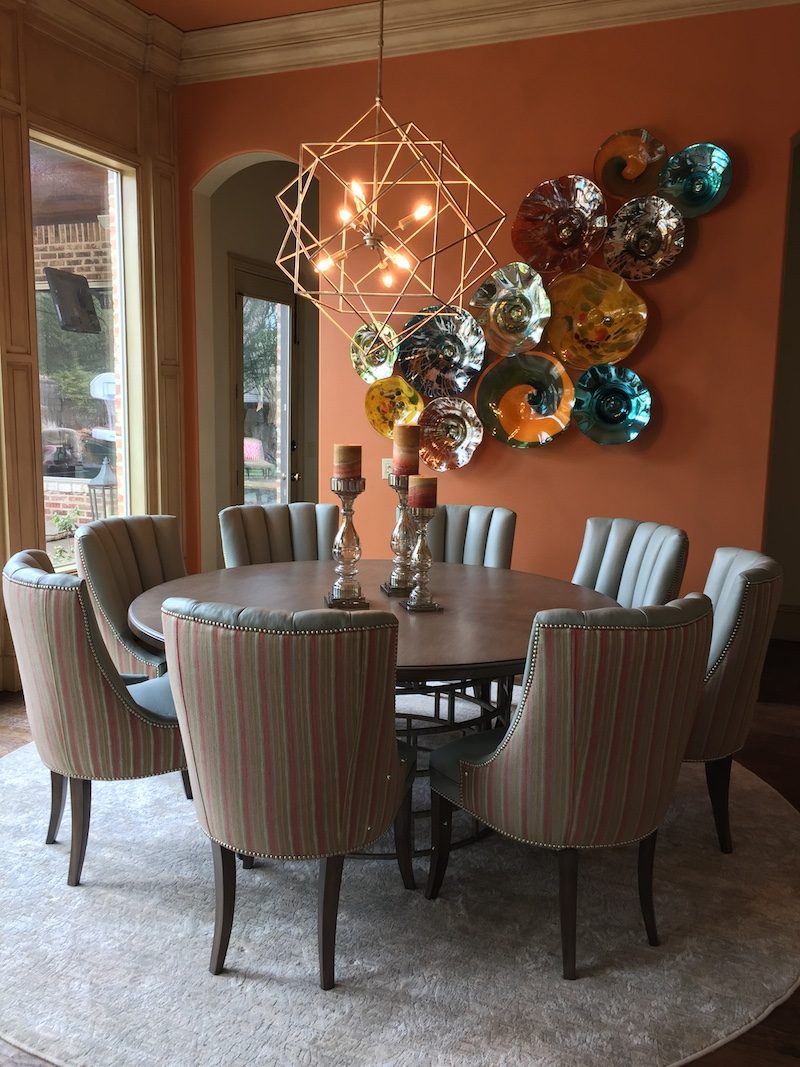 Dining room with a starburst wall arrangement and upholstered chairs