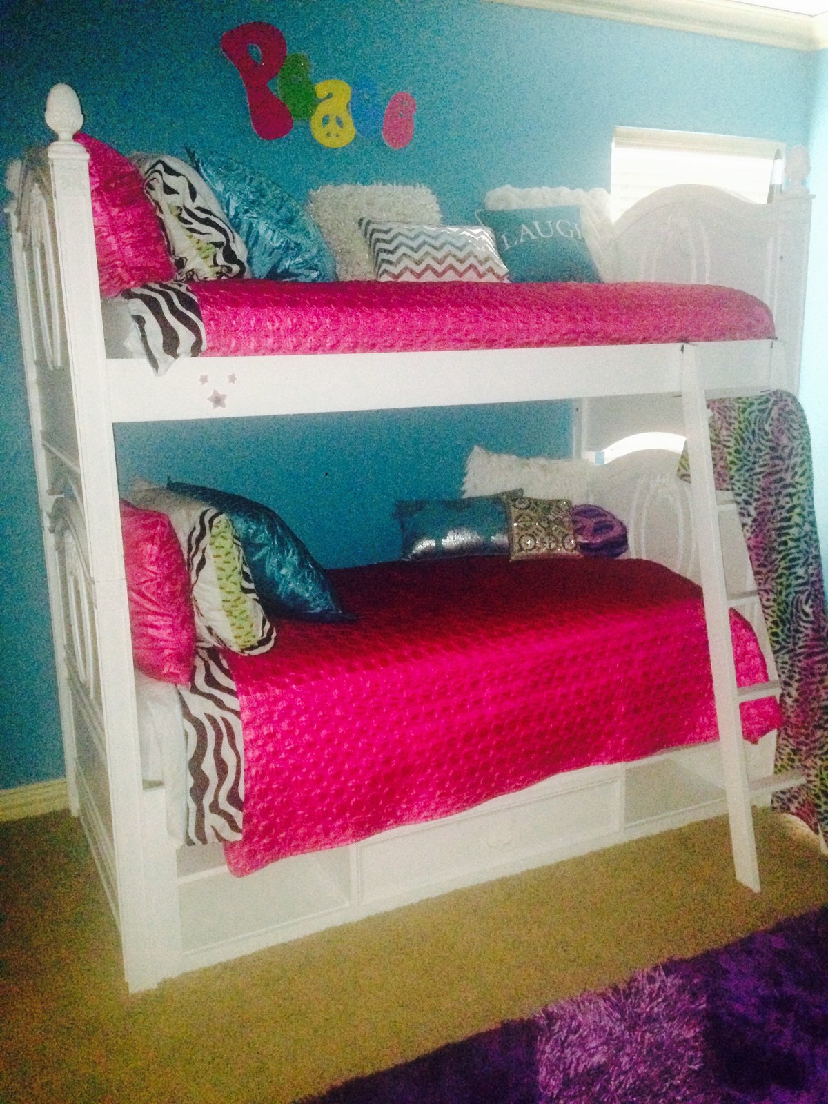 Bedroom with white bunk beds, hot pink bedding and a turquoise wall