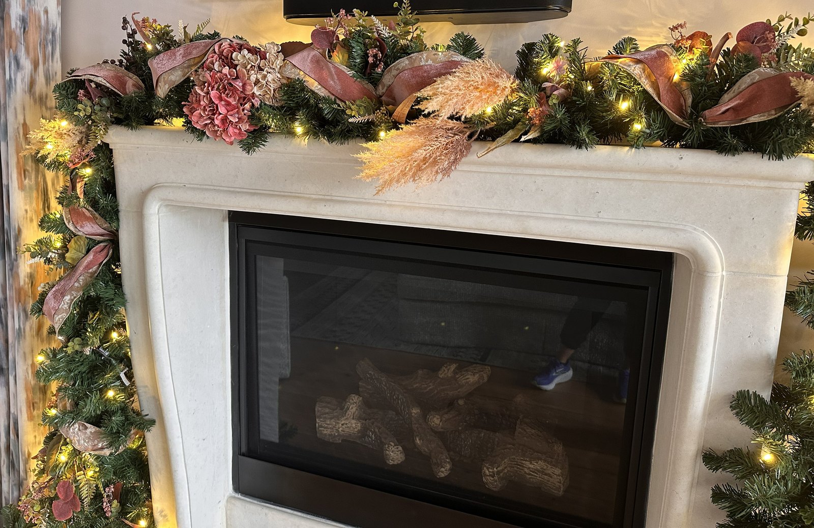Cast stone fireplace with a garland of blush hydrangea, pampas and dusty pink ribbon