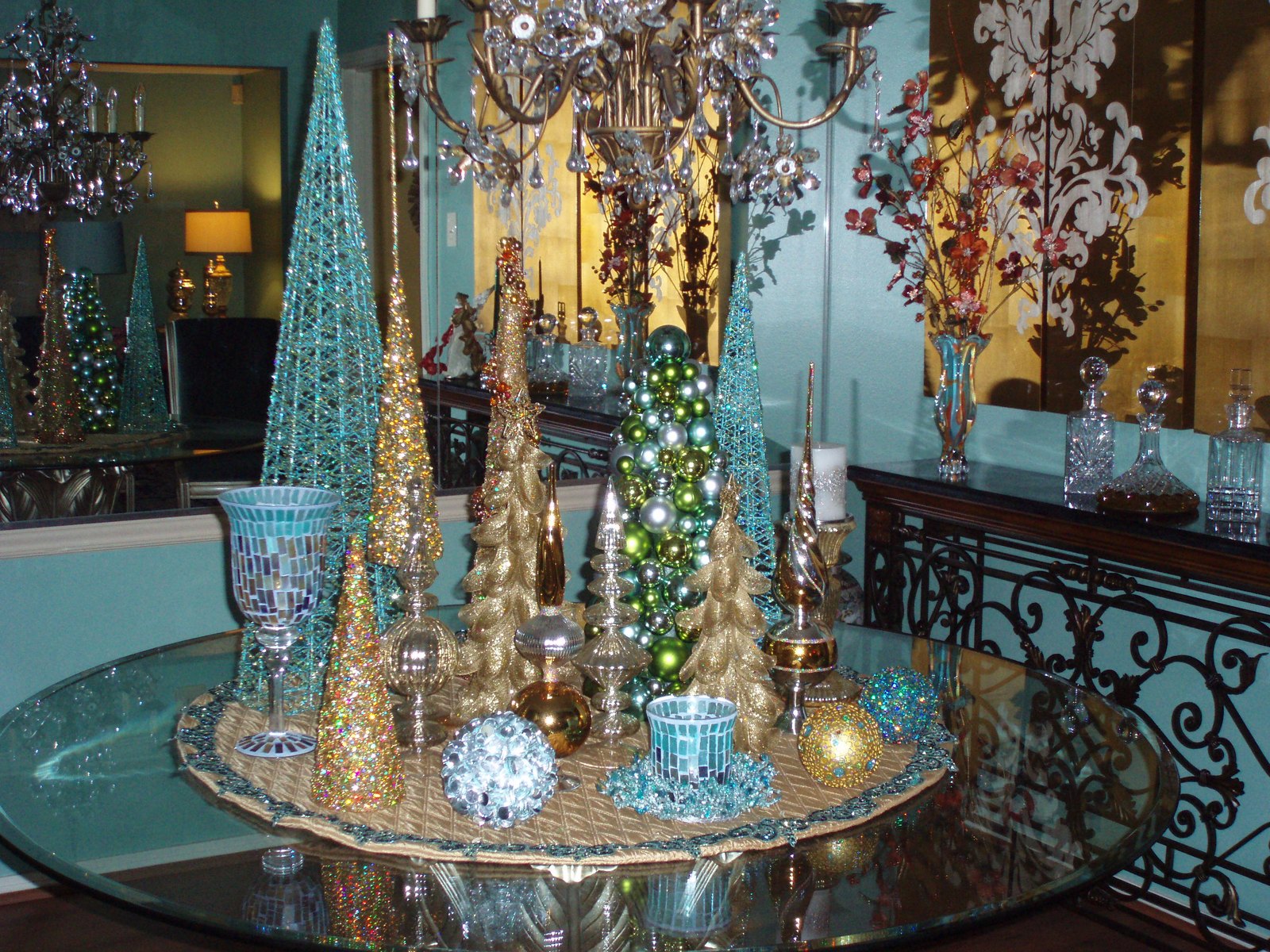 Glass table centrepiece of turquoise and gold cone trees with mercury glass accents