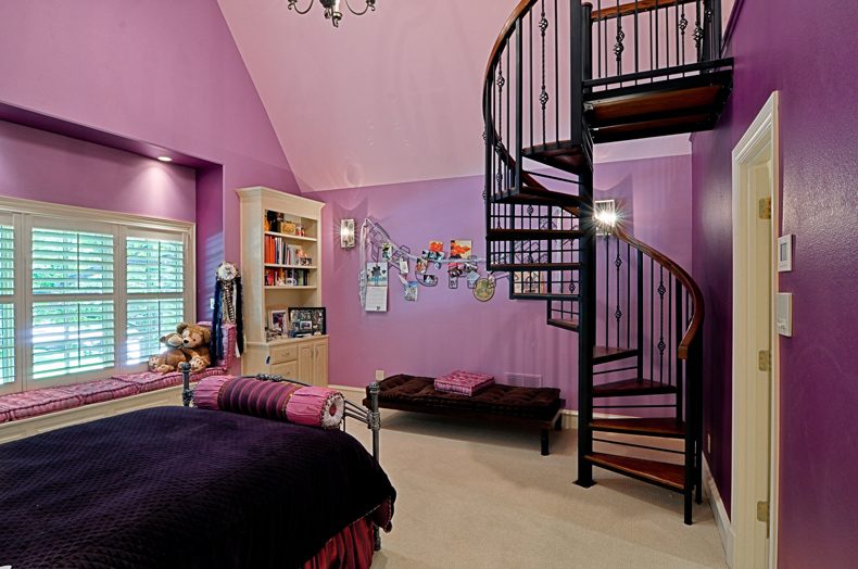 Room with strong purple walls and a black spiral staircase