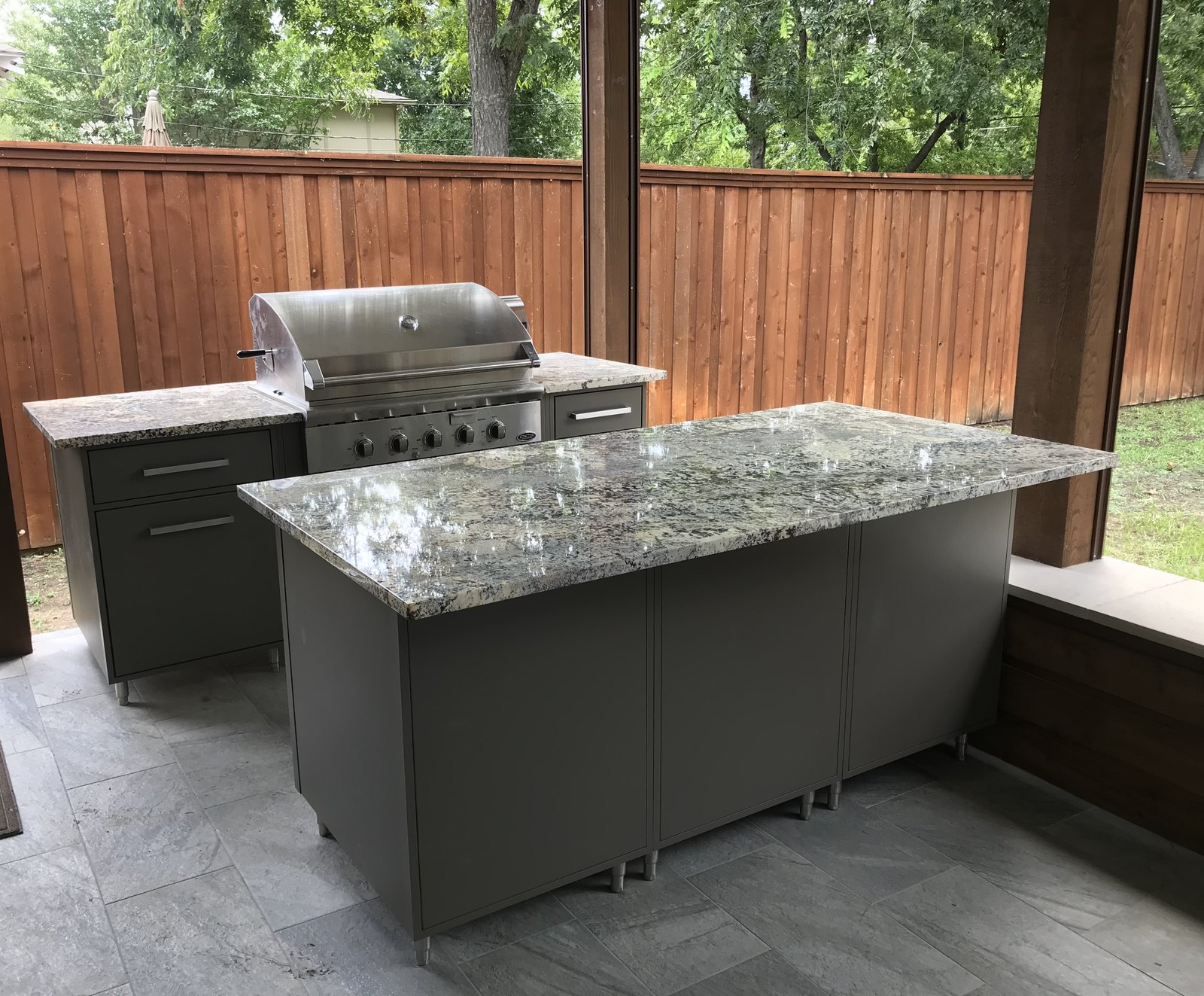 Covered outdoor kitchen with granite island and built-in grill