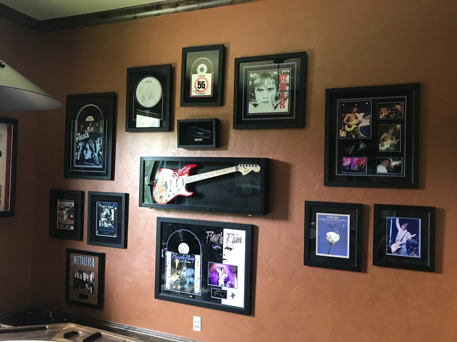 Wall of framed memorabilia and art arranged as a gallery in a media room