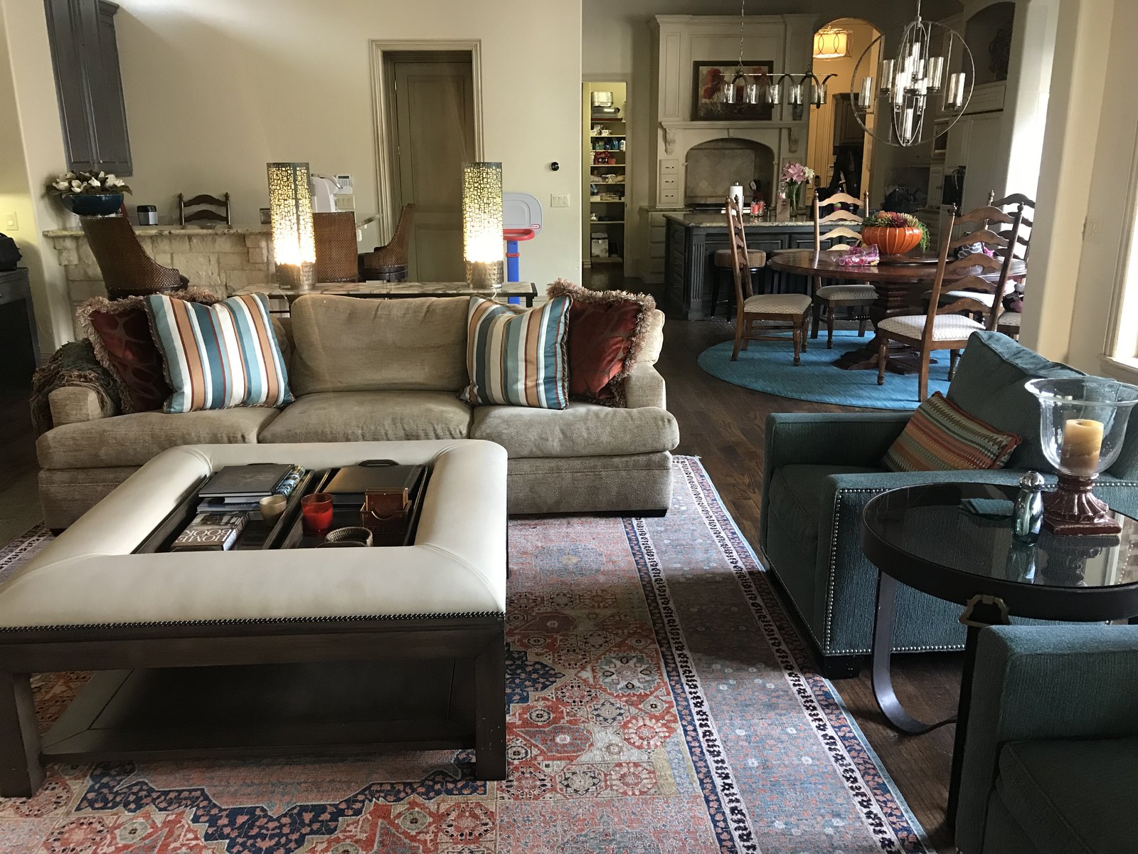 Open living and dining space with layered rugs and patterned pillows